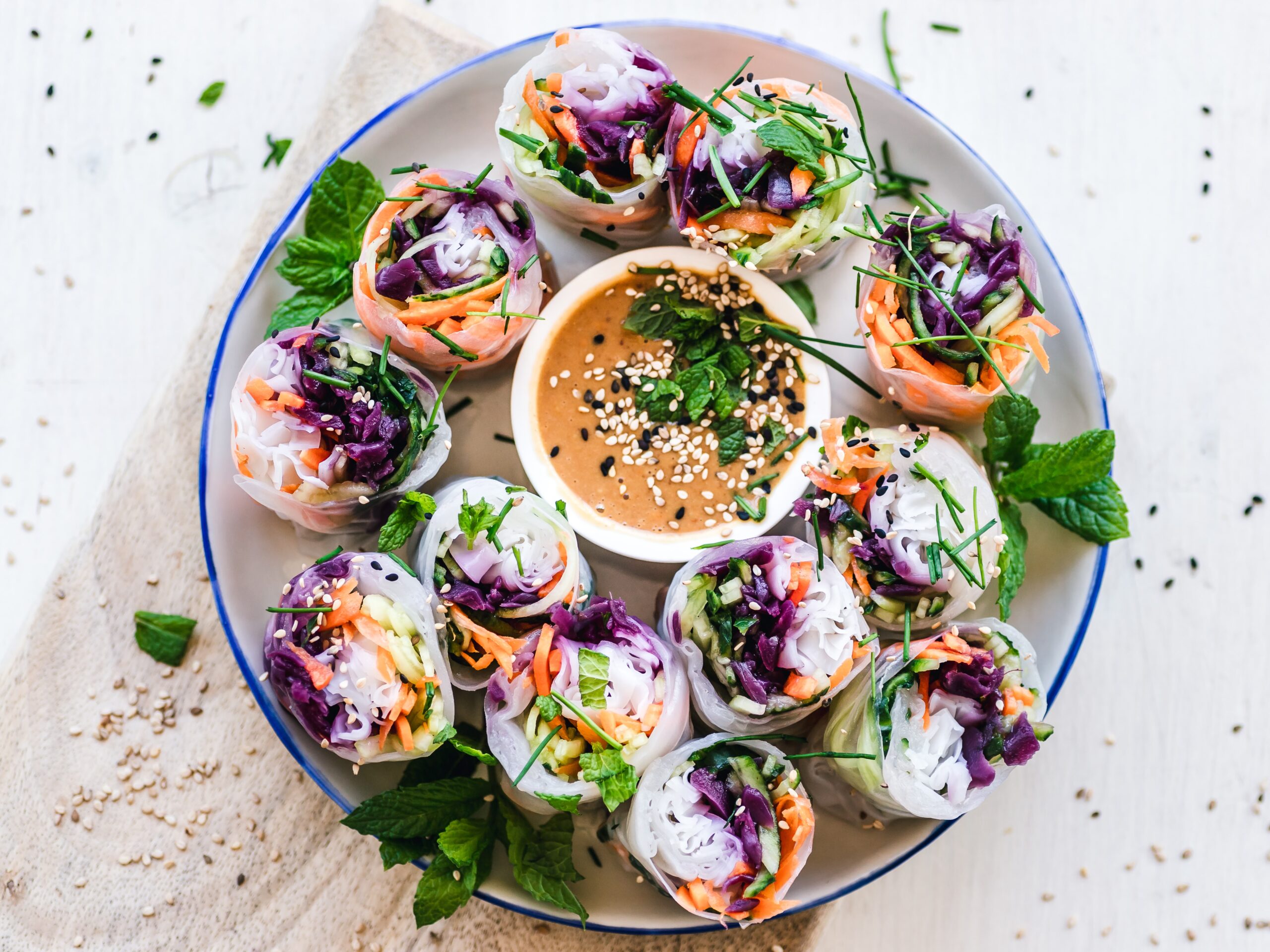 Rice paper rolls with a dipping sauce with red cabbage, carrot, mint, daikon radish