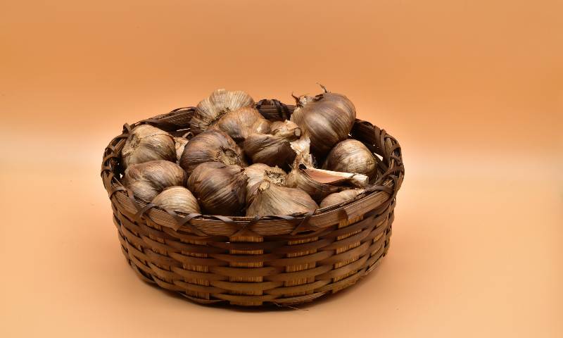 A basket of whole unpeeled black garlic